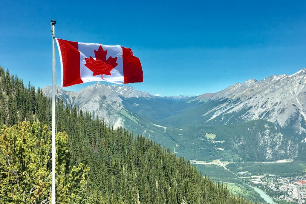 Kanadaflagge vor bergiger Landschaft