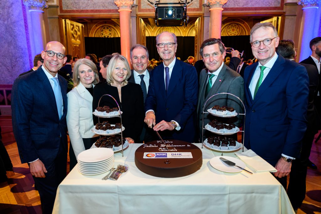 Österreichs Bundesminister Peter Hanke und DHK Präsident Dieter Pötsch mit Festgästen beim Anschneiden einer Torte